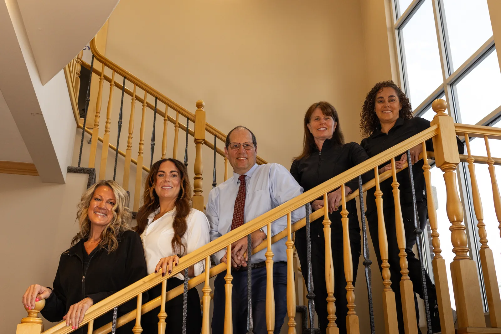 The dental team on the office staircase at the Rod Gleave, DMD dental office in Salt Lake City, UT